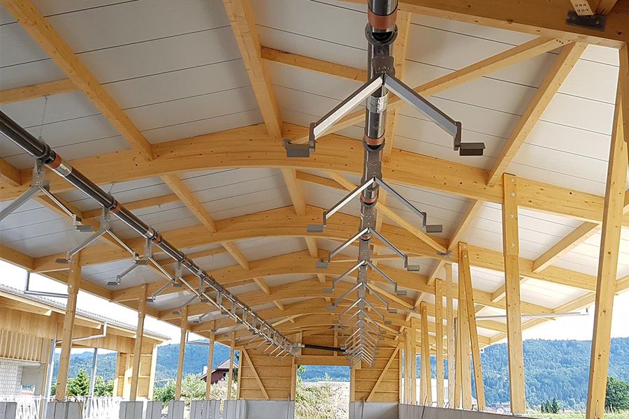 Strohverteiler in neuem Rinderstall mit Holzdecke
